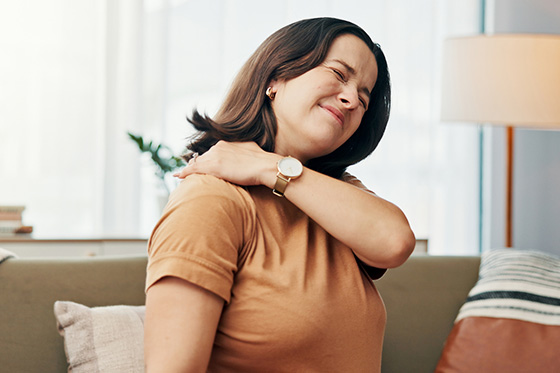 Мужчина хмурится из-за боли в плече